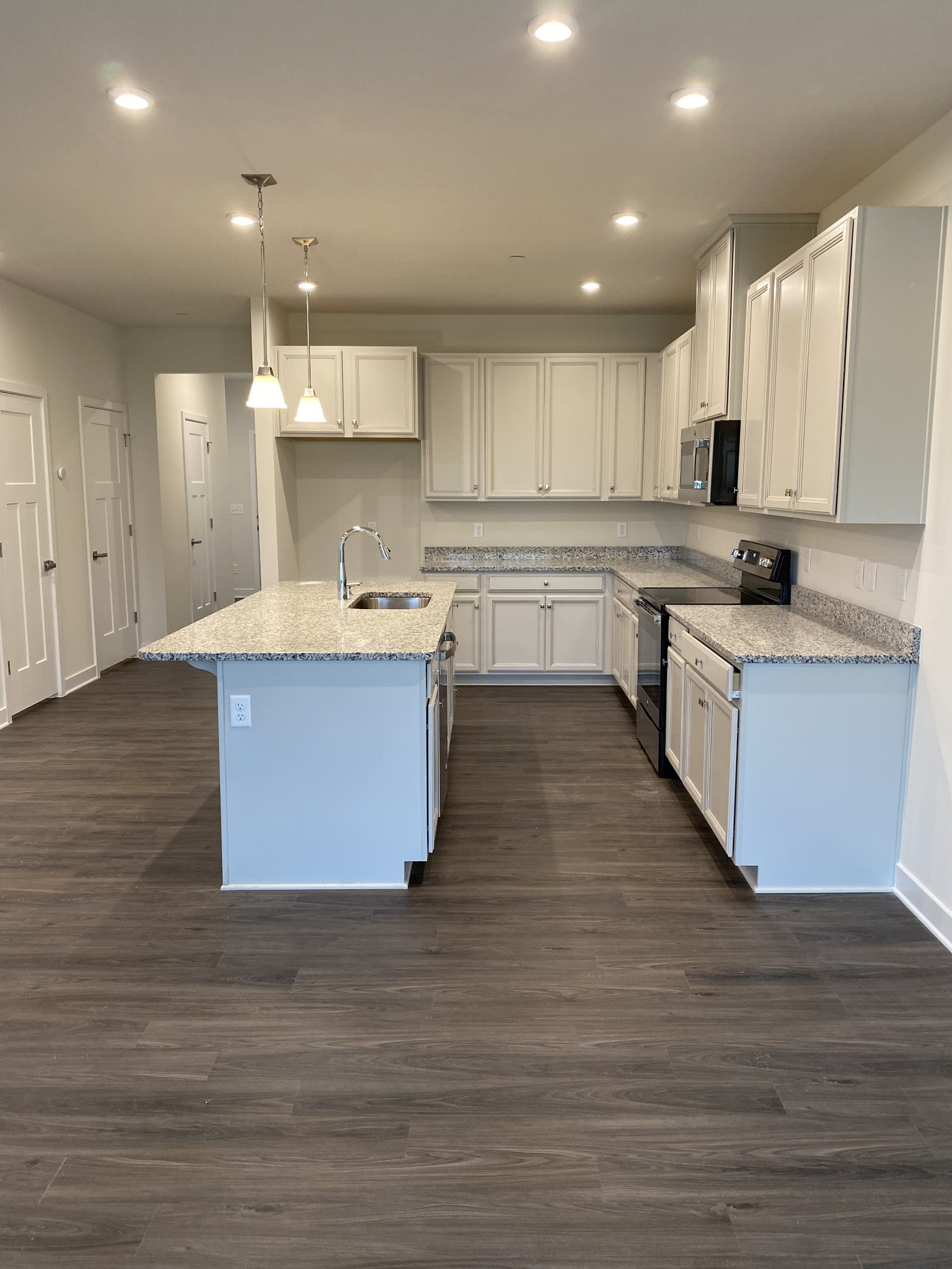 110 Keelon Gap Road, Unit 104C Spring Hill, TN 37174 - Photo 8 of 22 a large kitchen with cabinets wooden floor and stainless steel appliances