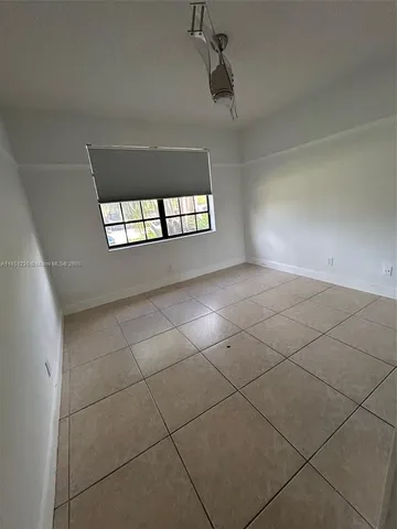 an empty room with windows and ceiling fan