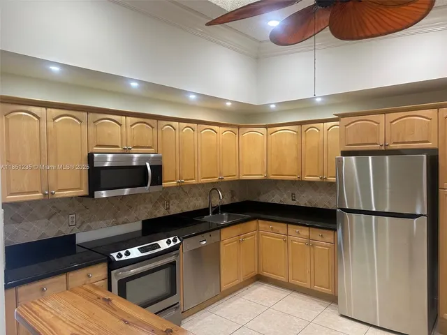 a kitchen with granite countertop a stove and cabinets