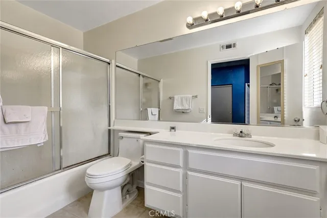 a bathroom with a sink a toilet and a large mirror