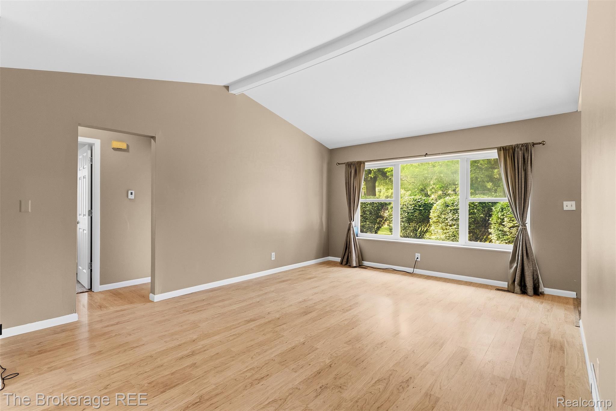 6509 Silver Lake Road Linden, MI 48451 - Photo 15 of 43 Spacious room featuring vaulted ceilings, light wood-finish flooring, and a large multi-pane window