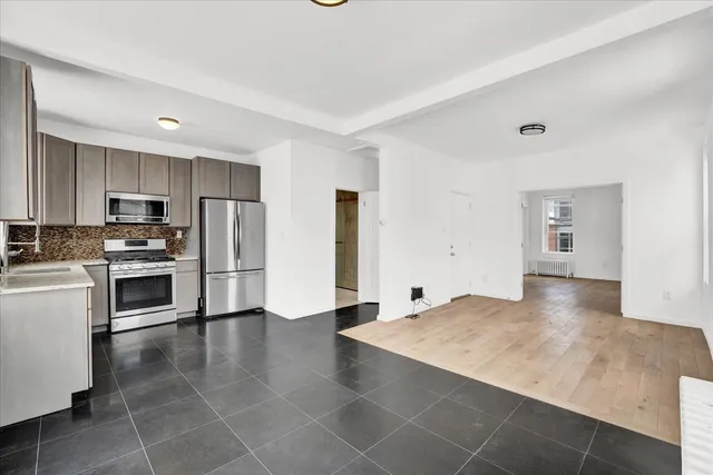 a view of a kitchen with wooden floor and electronic appliances