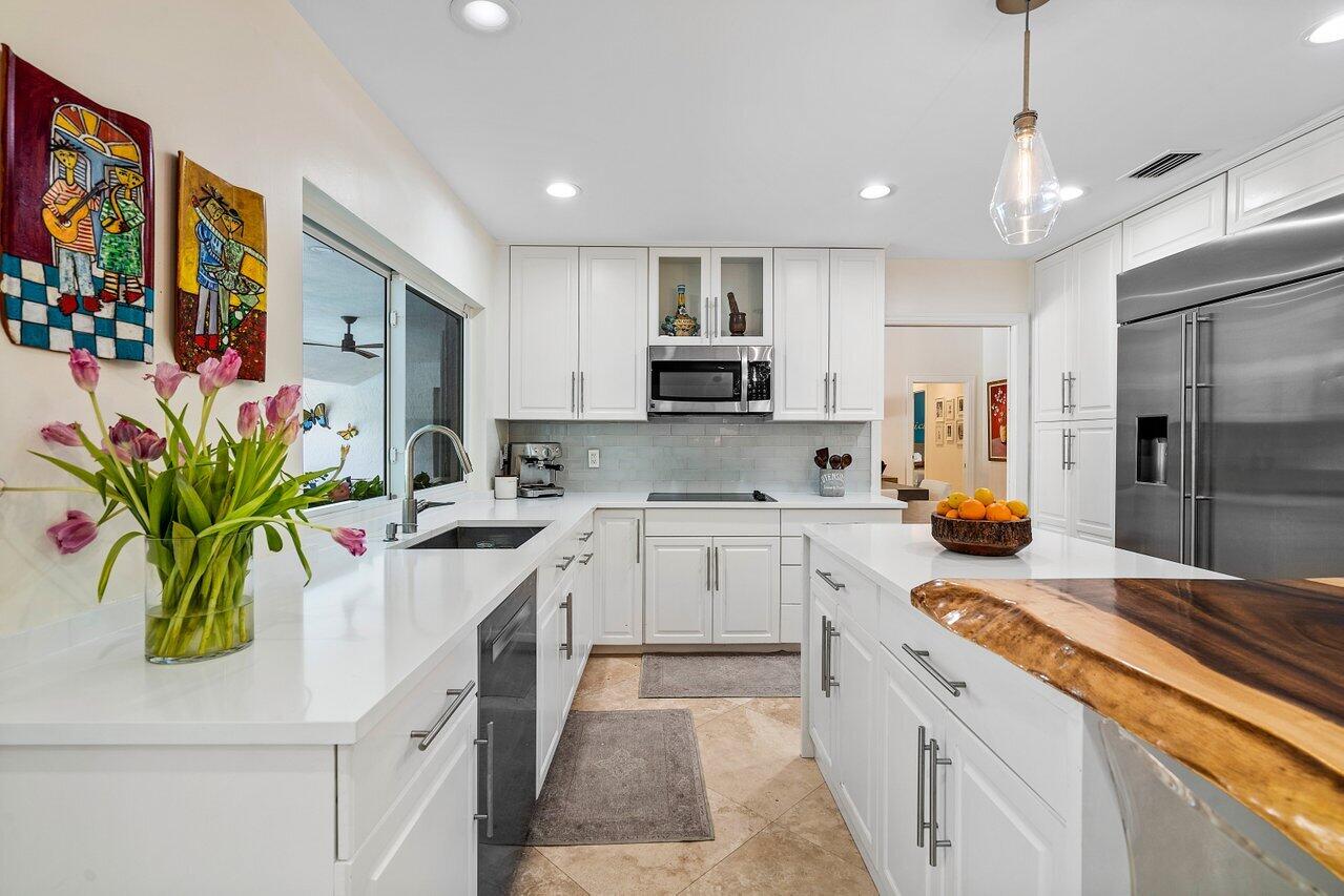 3765 Kings Way Boca Raton, FL 33434 - Photo 14 of 60 a kitchen with stainless steel appliances kitchen island sink refrigerator and cabinets
