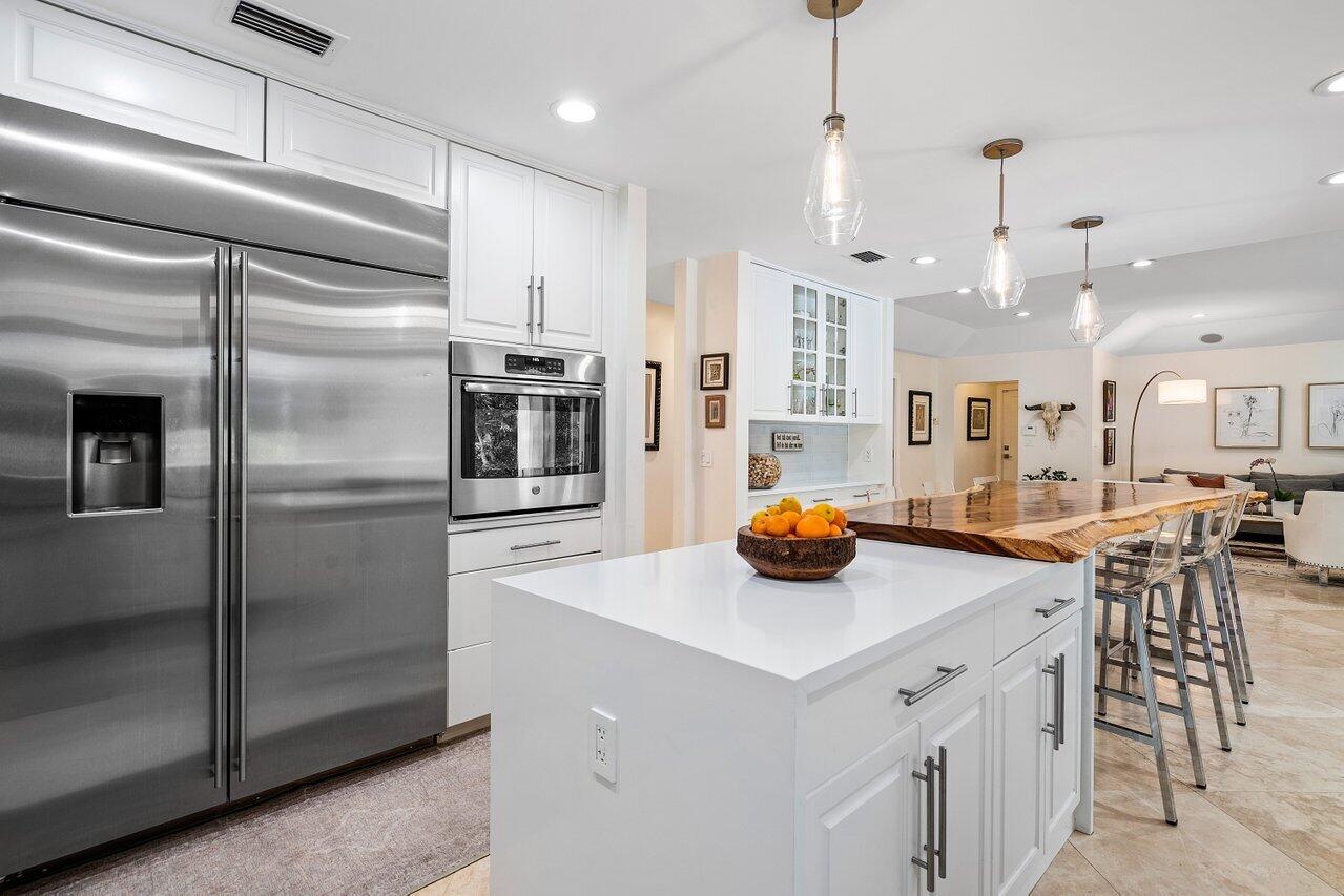 3765 Kings Way Boca Raton, FL 33434 - Photo 15 of 60 a kitchen with stainless steel appliances a refrigerator a stove a sink a dining table and chairs