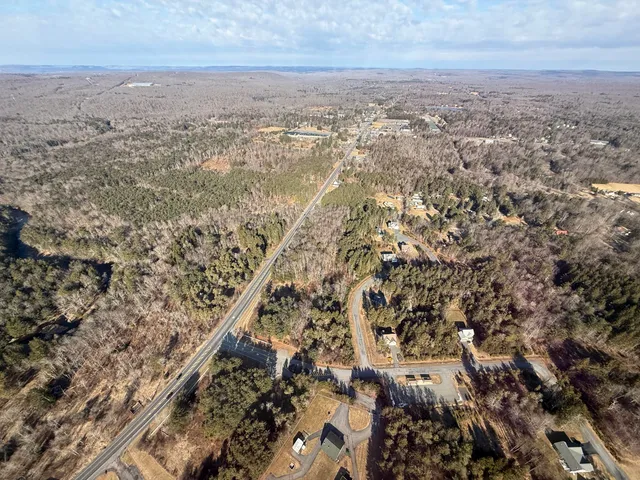 an aerial view of house with yard and mountain view in back