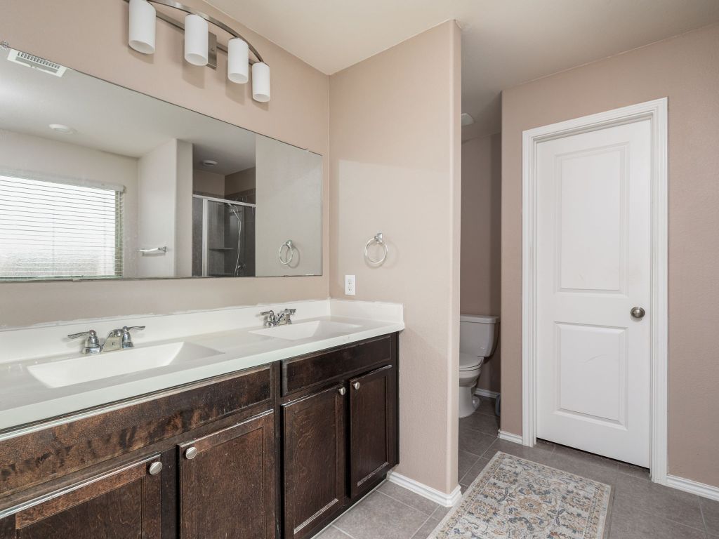 464 Druse Lane Jarrell, TX 76537 - Photo 14 of 26 a spacious bathroom with a double vanity sink and a mirror