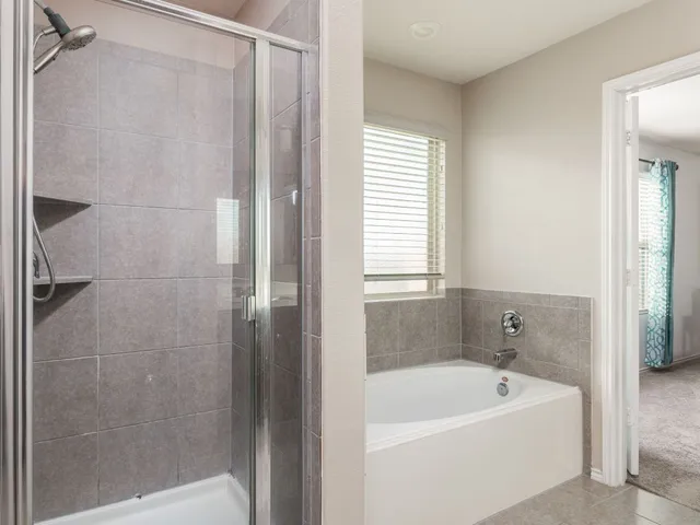a bathroom with a tub a window and a shower