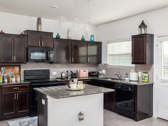 a kitchen with stainless steel appliances granite countertop a sink stove and microwave