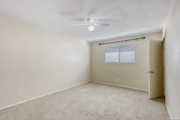 an empty room with a ceiling fan and a window