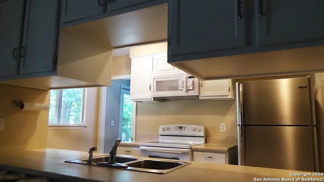 a kitchen with stainless steel appliances a refrigerator and a stove