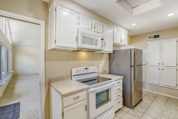 a kitchen with stainless steel appliances granite countertop a refrigerator and a stove