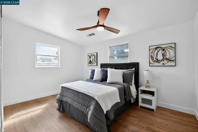a spacious bedroom with a bed and a painting on the wall