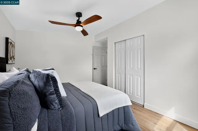 a bedroom with a bed and a ceiling fan