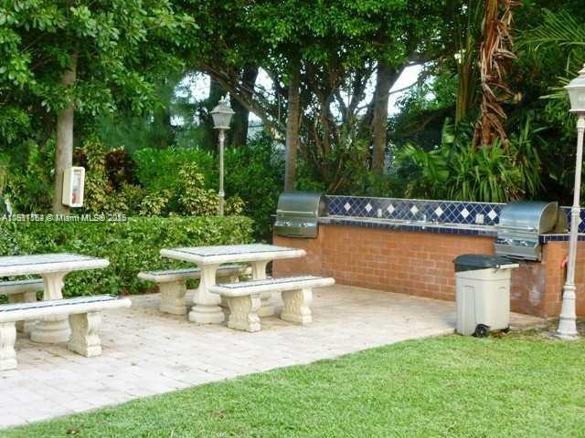 150 Southeast 25th Road, Unit 4C Miami, FL 33129 - Photo 14 of 23 a view of a patio with table and chairs potted plants and large tree
