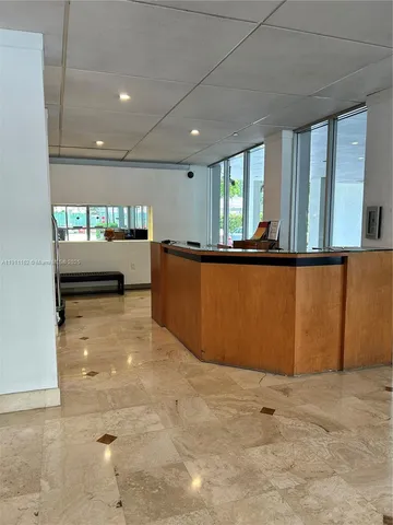 a front view of white house with large windows and a small yard