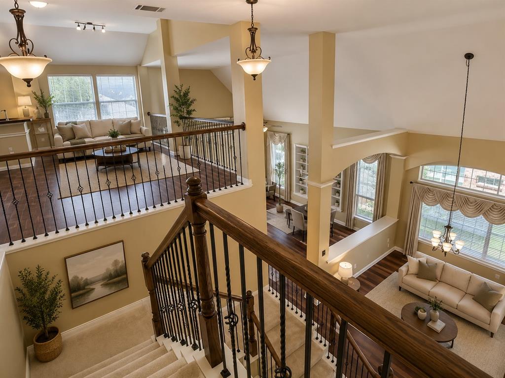 5708 Rickshaw Lane Plano, TX 75094 - Photo 21 of 28 Multi-level interior featuring a carpeted staircase with wood and wrought iron railing, vaulted ceilings, and wood-finish flooring