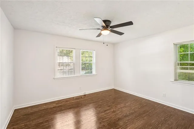 a view of a big room with wooden floor and windows in a room