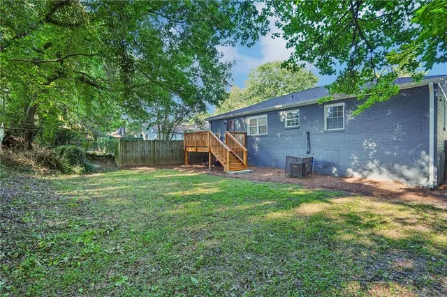 a view of a house with backyard and a tree