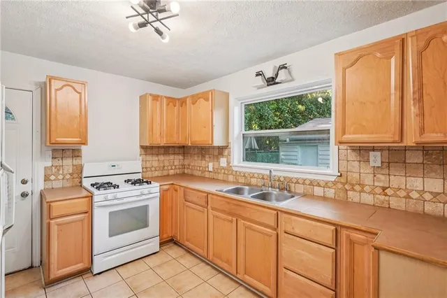 a kitchen with stainless steel appliances a stove a sink and a window