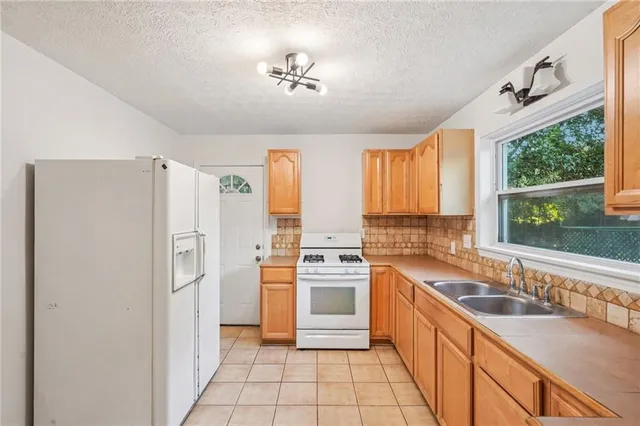 a kitchen with a refrigerator a sink and a window