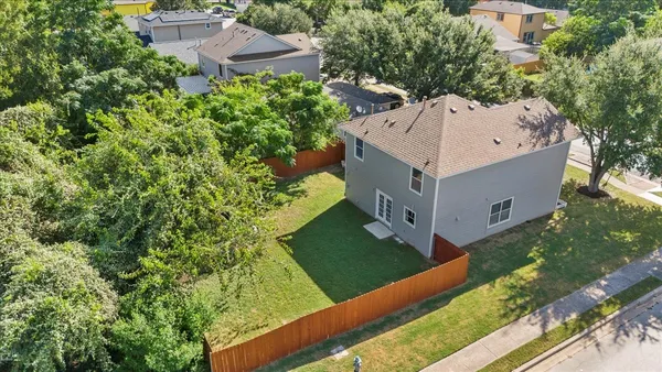 a view of a house with a yard and large tree