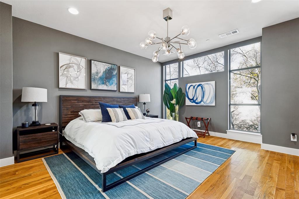 4618 Cedar Springs Road, Unit B Dallas, TX 75219 - Photo 20 of 24 a bedroom with a bed lamps and wooden floor