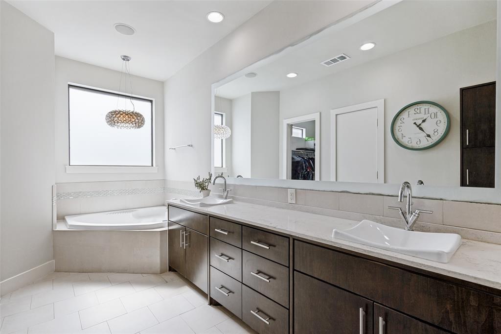 4618 Cedar Springs Road, Unit B Dallas, TX 75219 - Photo 21 of 24 a bathroom with a double vanity sink and a bathtub