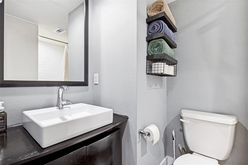 4618 Cedar Springs Road, Unit B Dallas, TX 75219 - Photo 5 of 24 a bathroom with a toilet sink and mirror