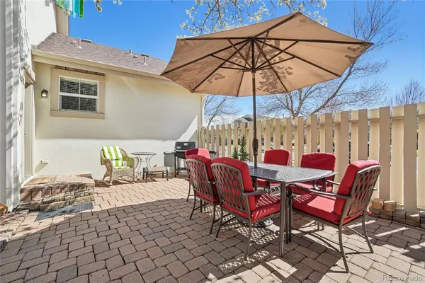 a view of a patio with a table and chairs under an umbrella