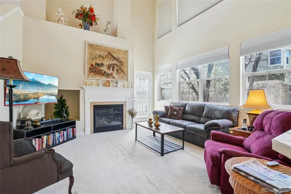 a living room with furniture a fireplace a lamp and a window
