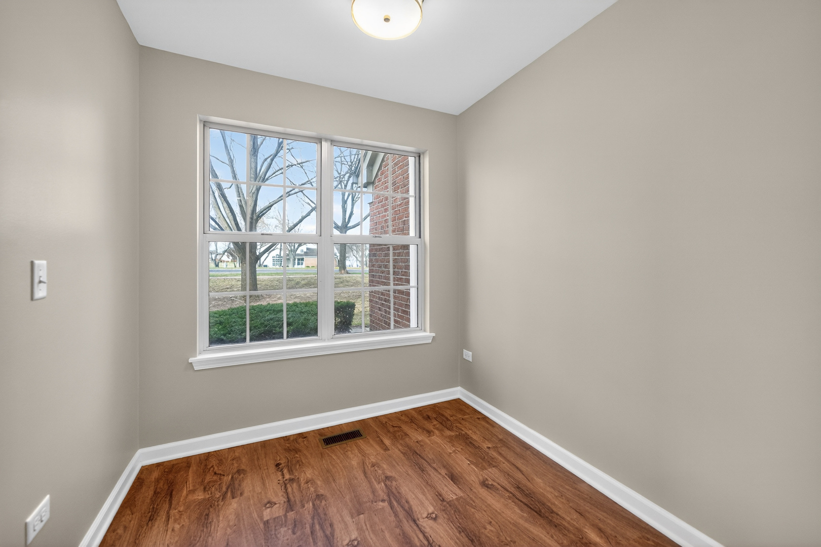 446 Cromwell Circle, Unit 4 Bartlett, IL 60103 - Photo 14 of 18 a view of an empty room with wooden floor and a window