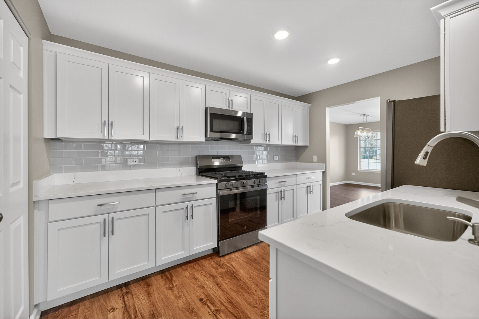 446 Cromwell Circle, Unit 4 Bartlett, IL 60103 - Photo 8 of 18 a kitchen with white cabinets sink and stainless steel appliances