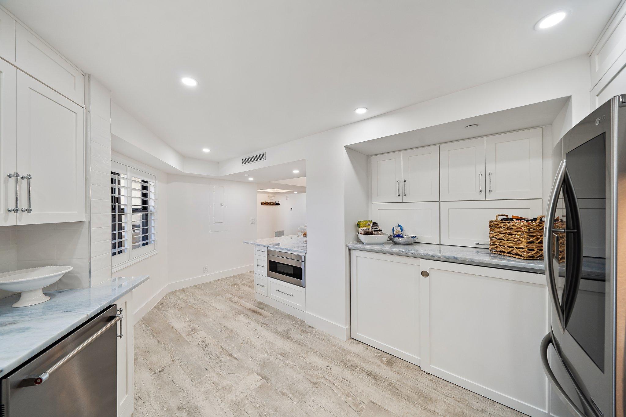 19800 Sandpointe Bay Drive, Unit 210 Jupiter, FL 33469 - Photo 30 of 59 a kitchen with stainless steel appliances a refrigerator sink and white cabinets