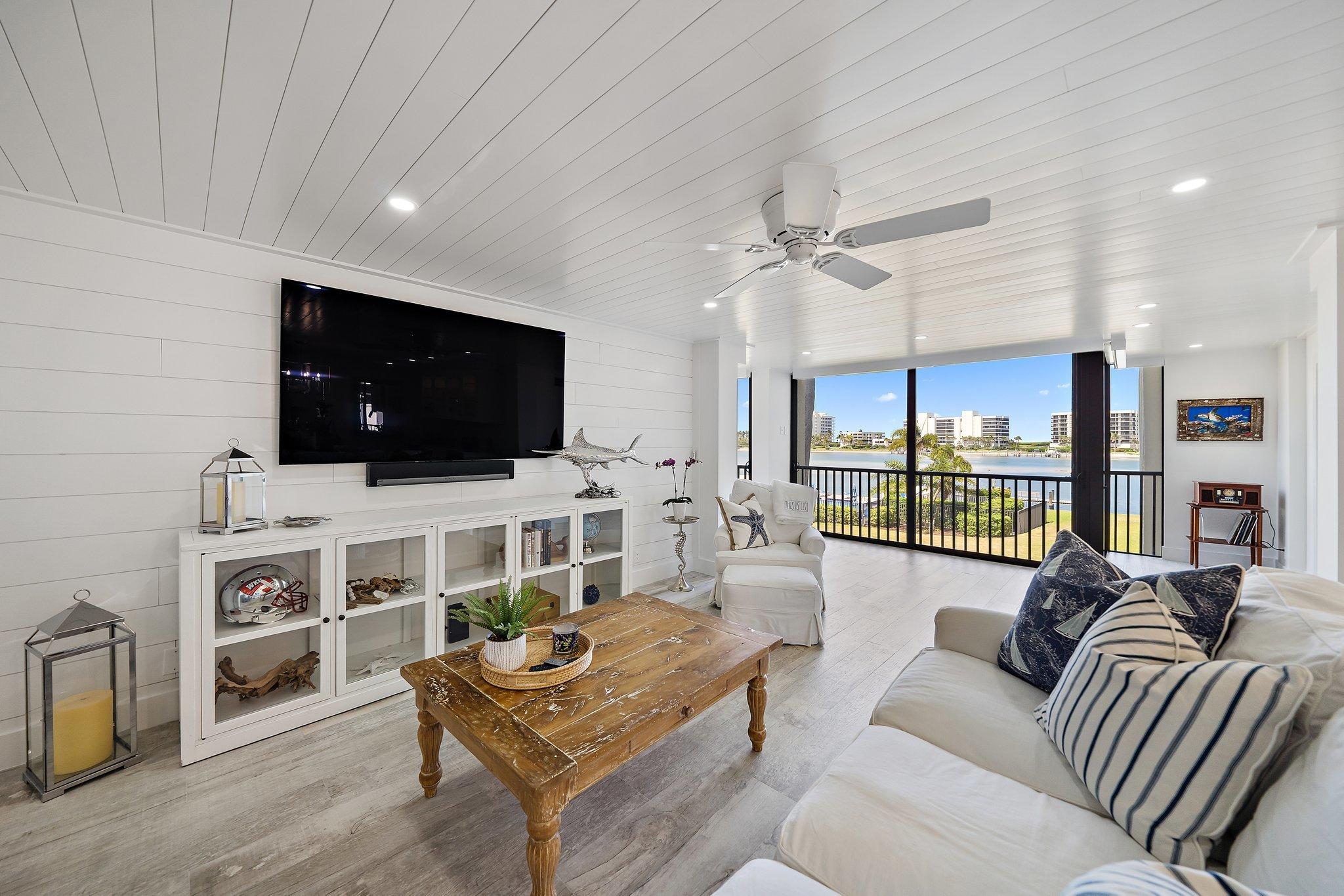 19800 Sandpointe Bay Drive, Unit 210 Jupiter, FL 33469 - Photo 32 of 59 a living room with furniture and a flat screen tv