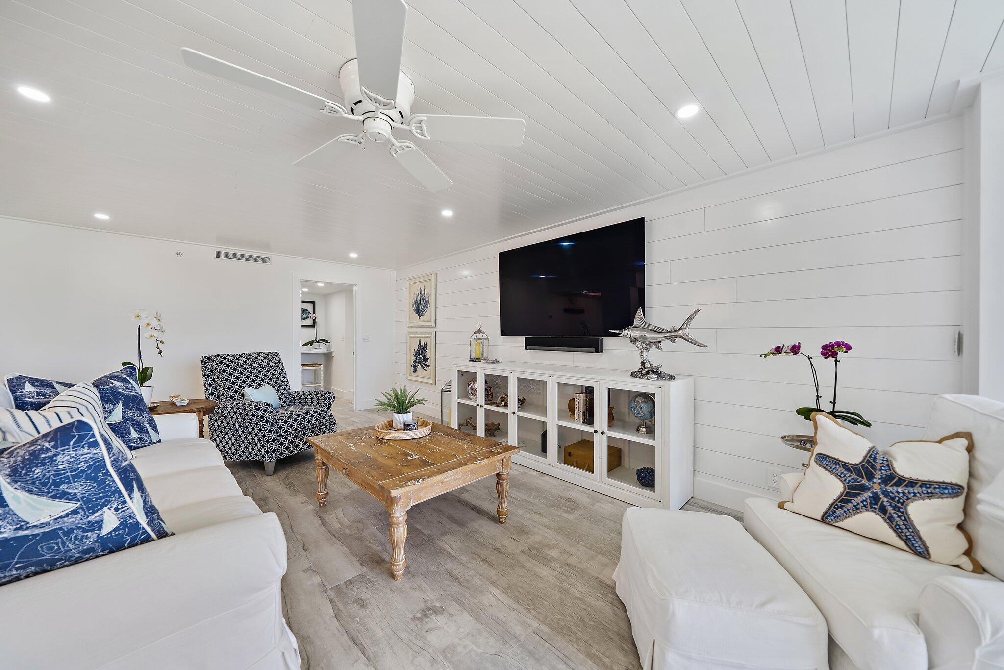 19800 Sandpointe Bay Drive, Unit 210 Jupiter, FL 33469 - Photo 33 of 59 a living room with furniture and a flat screen tv