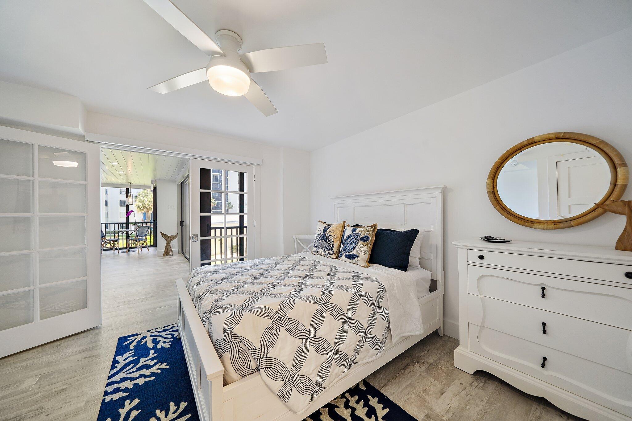 19800 Sandpointe Bay Drive, Unit 210 Jupiter, FL 33469 - Photo 41 of 59 a bedroom with a large bed and a chandelier