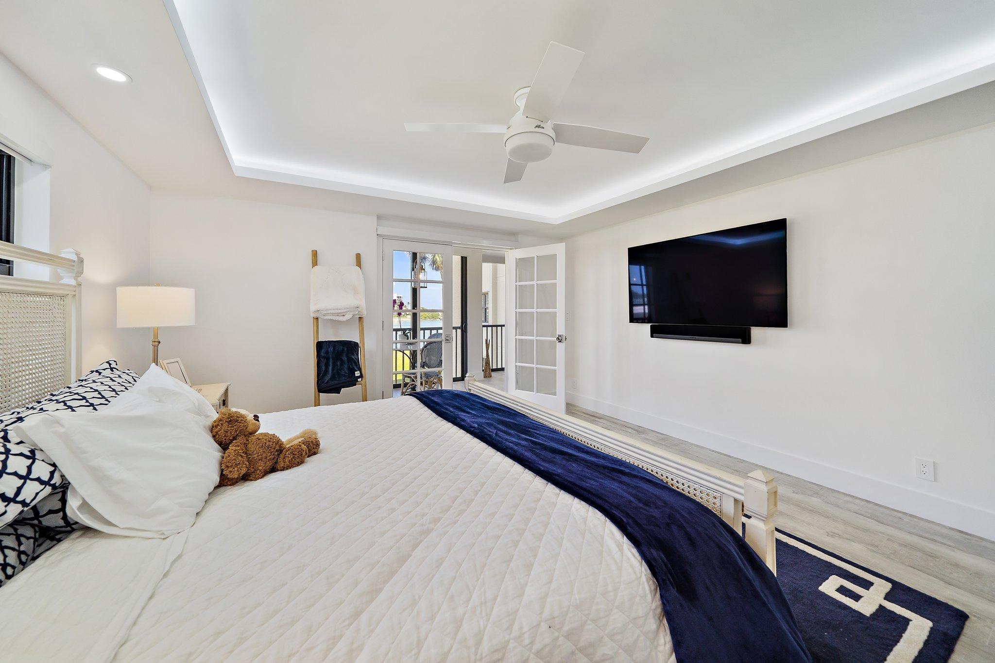 19800 Sandpointe Bay Drive, Unit 210 Jupiter, FL 33469 - Photo 46 of 59 a bedroom with a bed tv and a window