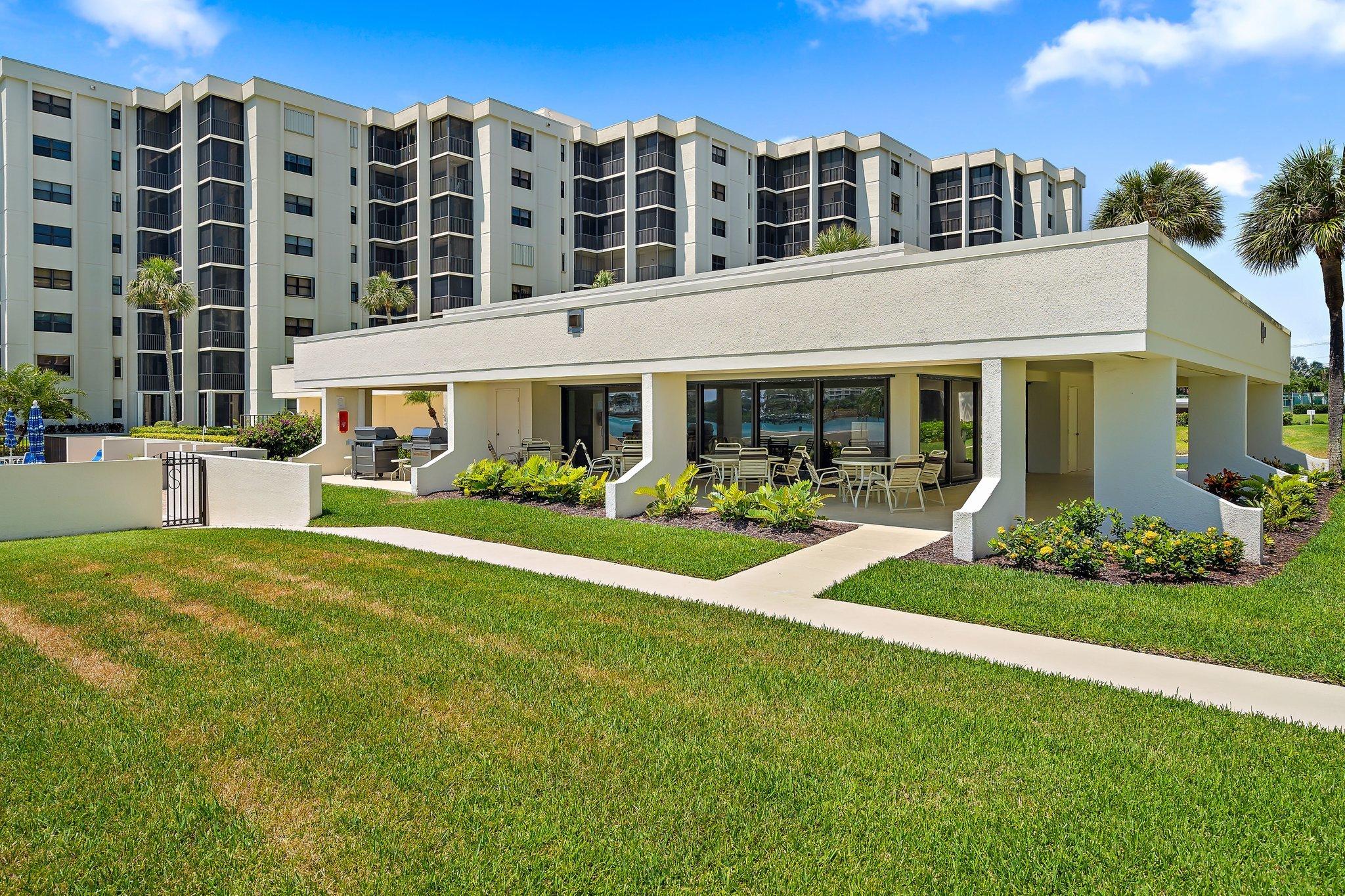 19800 Sandpointe Bay Drive, Unit 210 Jupiter, FL 33469 - Photo 48 of 59 a front view of building with outdoor seating and yard