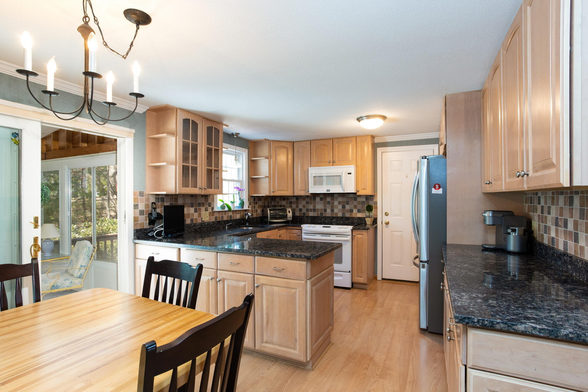91 Hawser Bend Centerville, MA 02632 - Photo 4 of 42 a kitchen with a table chairs refrigerator and cabinets
