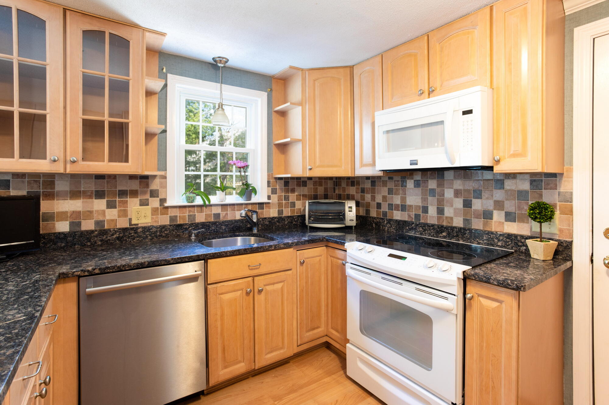 91 Hawser Bend Centerville, MA 02632 - Photo 5 of 42 a kitchen with stainless steel appliances granite countertop a stove a sink and white cabinets