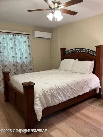a bedroom with a large bed a chandelier and a window