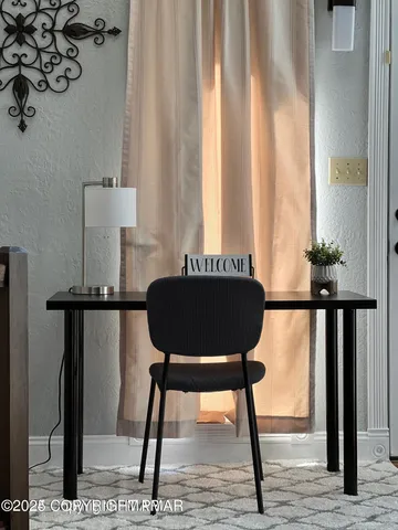 a view of a workspace room with furniture and window