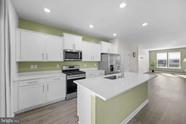 a kitchen with a sink a stove a microwave and cabinets