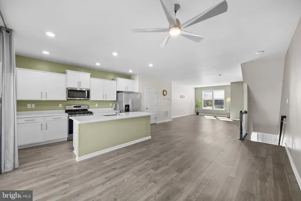 a kitchen with a refrigerator and a stove top oven