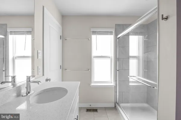 a bathroom with a granite countertop sink and a large mirror