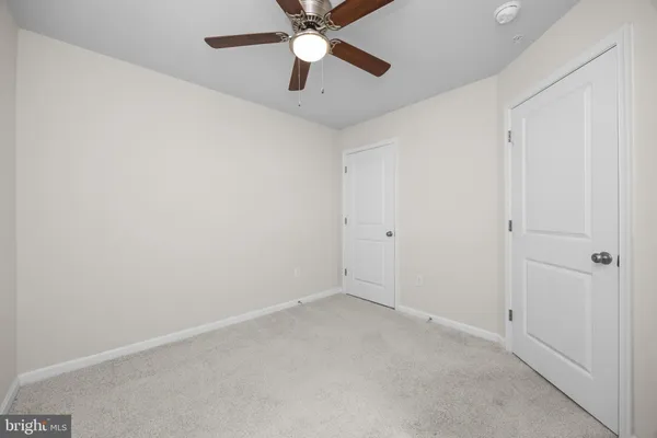 an empty room with a ceiling fan and fan