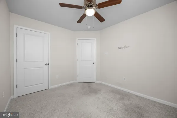 an empty room with chandelier fan