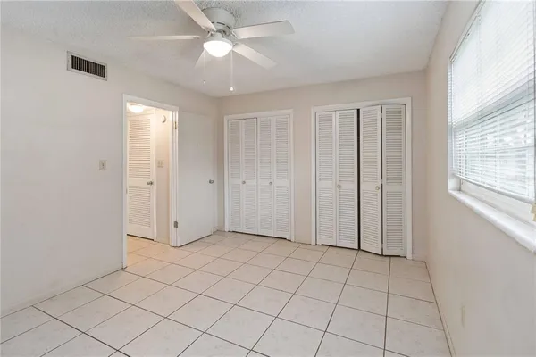 an empty room with closet and windows
