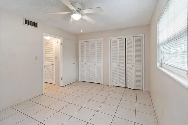 an empty room with closet and windows