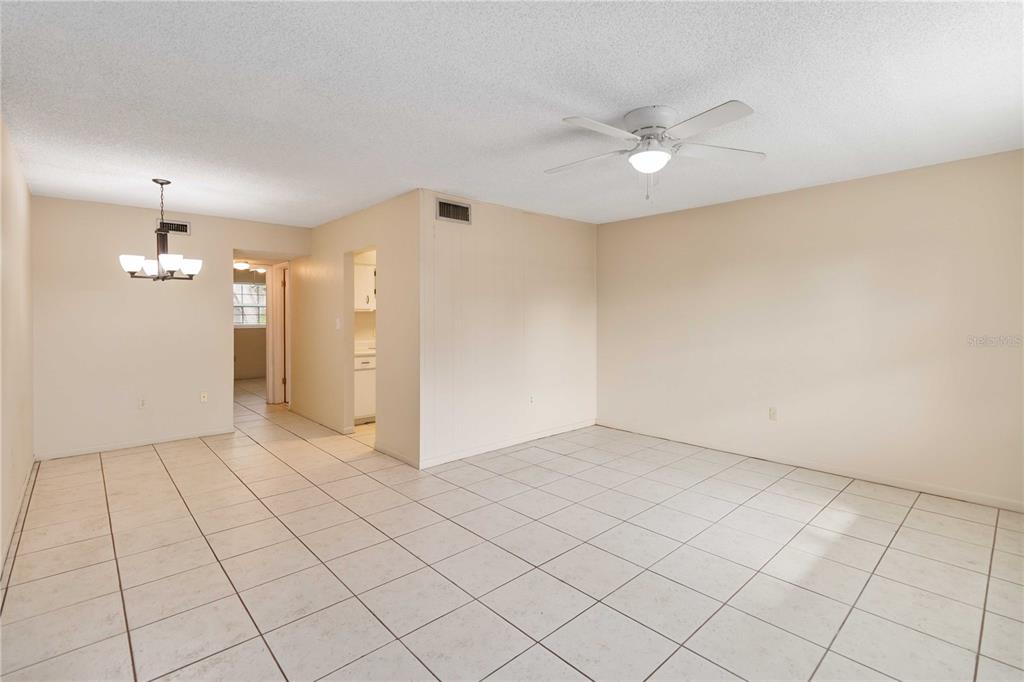 2500 Lee Road, Unit 244 Winter Park, FL 32789 - Photo 10 of 26 an empty room with a chandelier fan and kitchen view